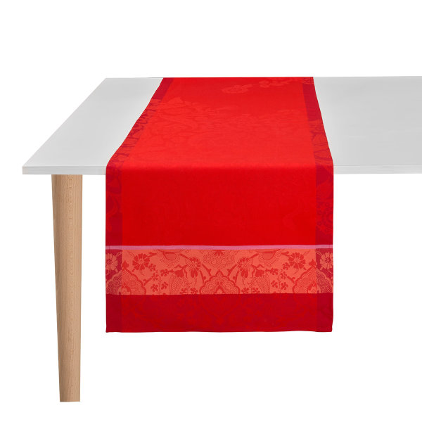 Chemin de table de Le Jacquard Français; Model Voyage Iconique Coquelicot; Couleur principale rouge en coton; Taille 50x150 cm rectangulaire; Motif Fleurs et plantes, dessins graphiques tissé jacquard