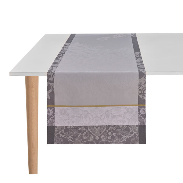 Table runner from Le Jacquard Français; Model Voyage Iconique Zinc; main colour grey in cotton; Size 50x150 cm rectangular; Motif Flowers and plants, graphic patterns; Pattern jacquard woven