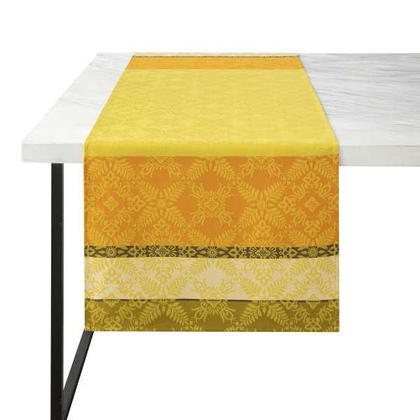 Camino de mesa de Le Jacquard Français; Modelo Mumbai Safran; Color principal amarillo en algodón; Tamaño 50x150 cm rectangular; Motivo diseños gráficos en tejido jacquard